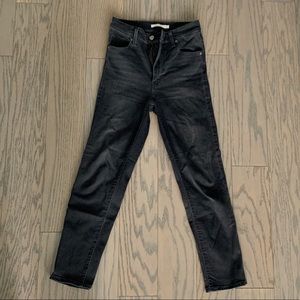 High-waisted, washed out black skinny Levi jeans.